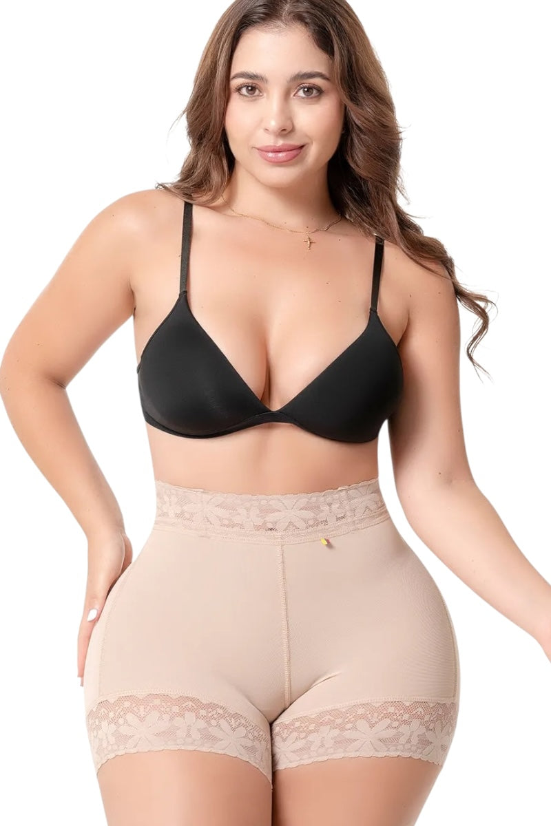 Woman wearing a black bra and beige shapewear on a white background
