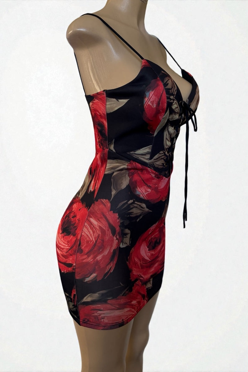 Mannequin wearing a black dress with red floral patterns on a white background