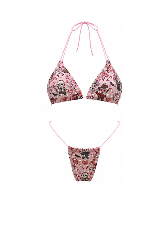 A two-piece bikini set featuring a pink triangle top and matching low-rise bottoms, both decorated with a detailed graphic print of characters, roses, and hearts, with thin pink strings.