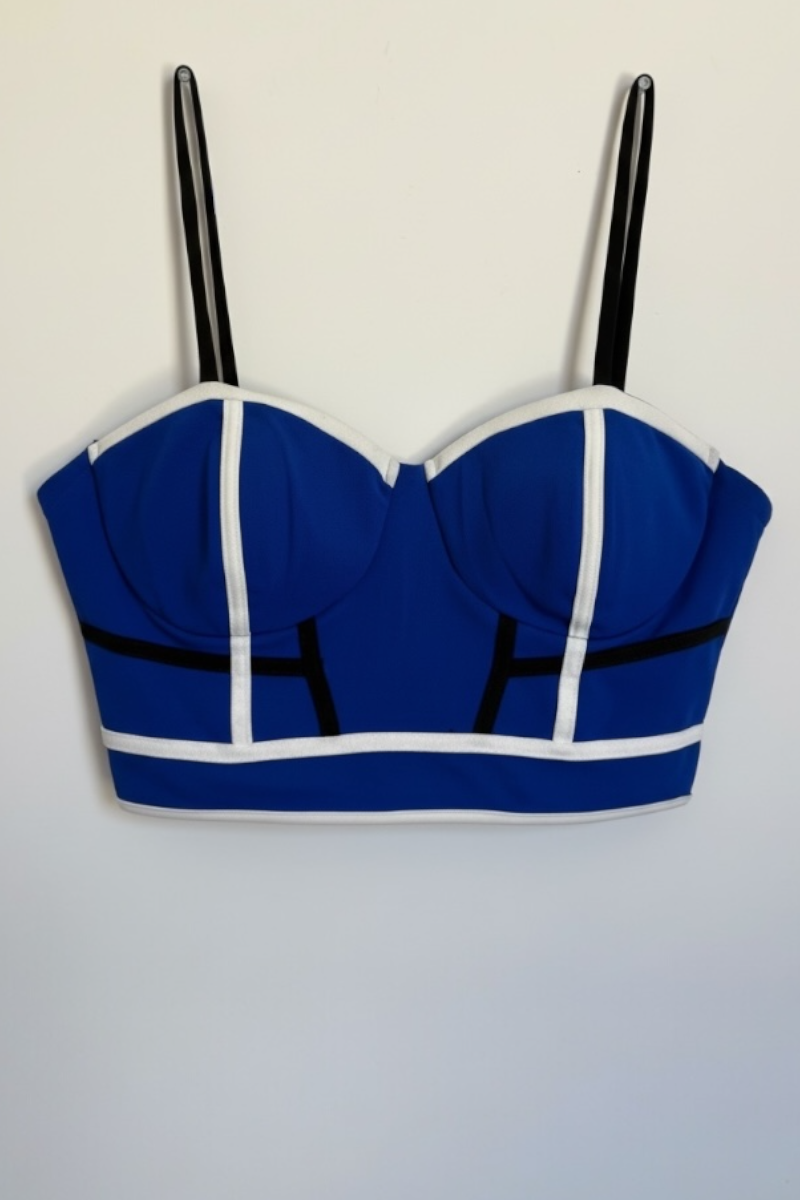 Blue crop top with black straps on a light gray background