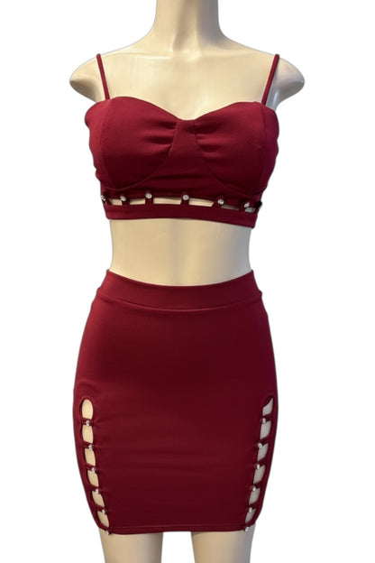 burgundy two-piece outfit with cut-out details on a mannequin against a white background