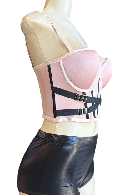 Mannequin wearing a rose top with black straps on a white background