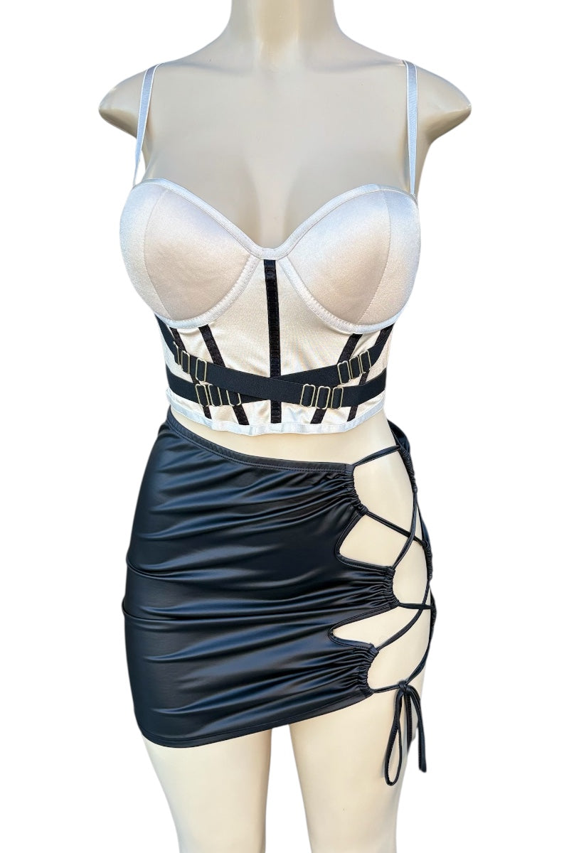 Mannequin wearing a black and beige outfit with a crop top and faux leather skirt.