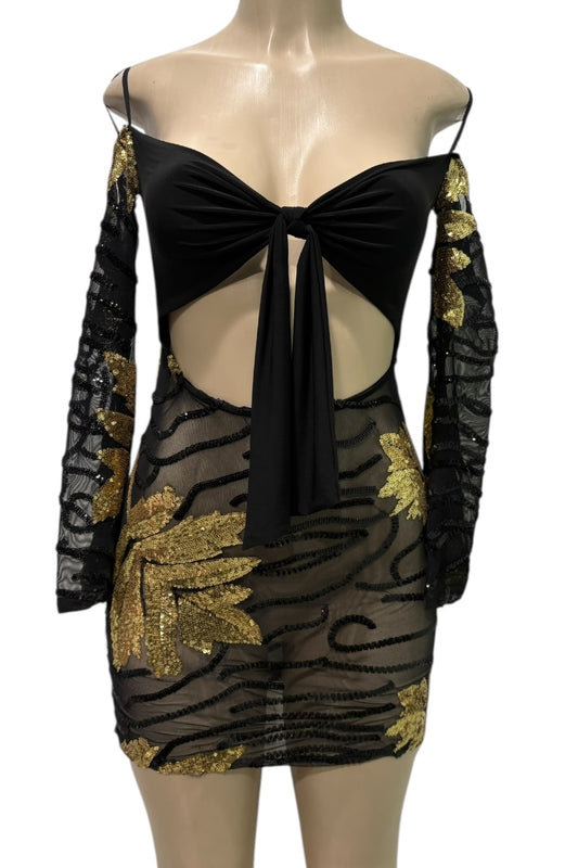 Black dress with gold accents on a mannequin against a white background