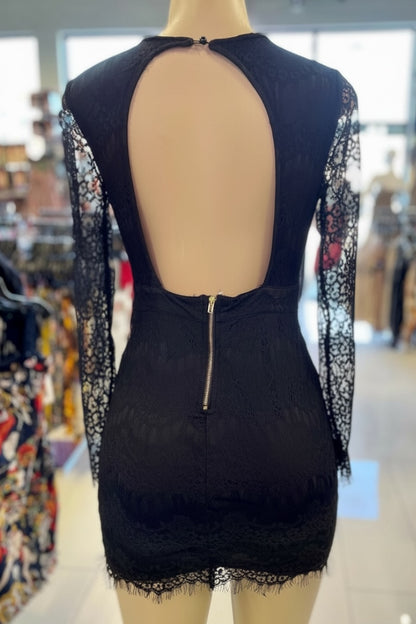 Black lace dress on a mannequin with a blurred store background