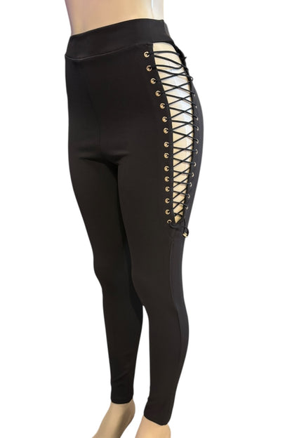 Black leggings with gold lace-up design on a white background