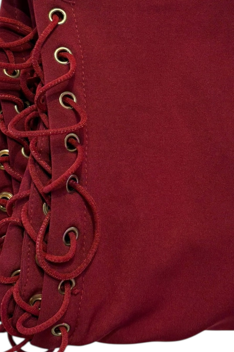 Close-up of a burgundy fabric with lace detailing on a plain background