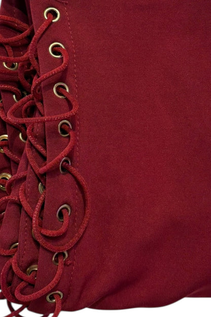 Close-up of a burgundy fabric with lace detailing on a plain background