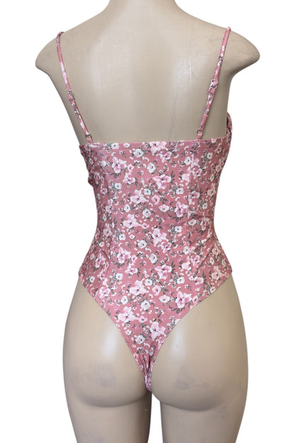 Pink floral bodysuit on a mannequin against a white background