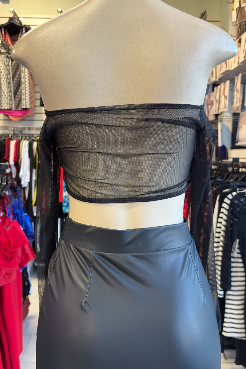 Mannequin wearing a black skirt with a sheer top in a store setting