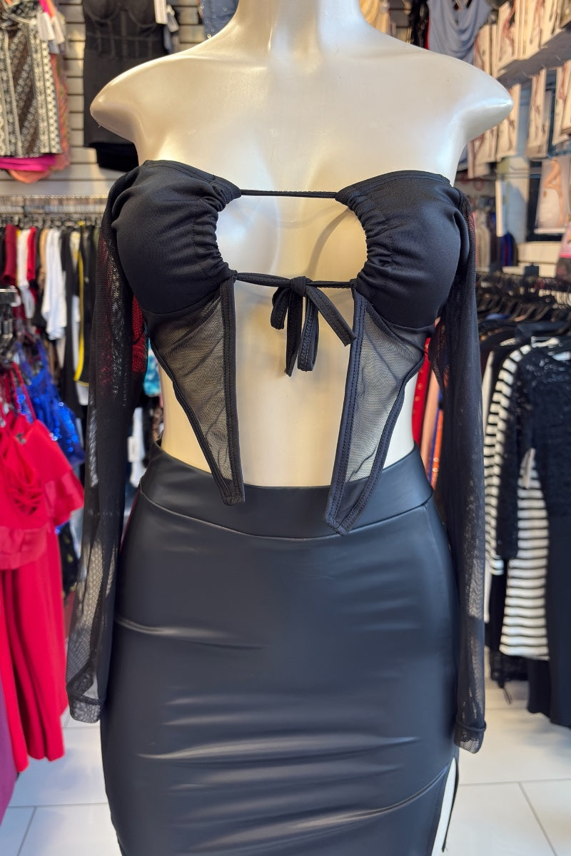Black top and a faux leather skirt on a mannequin in a store setting