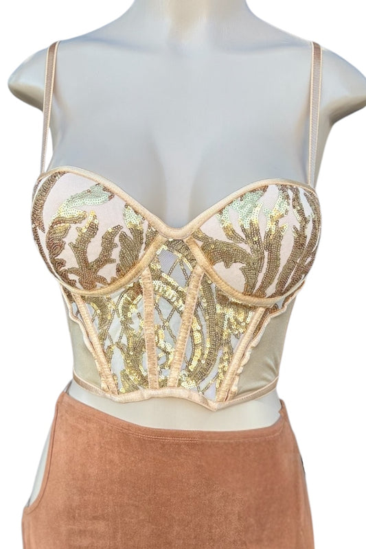 Mannequin wearing a golden sequined top and brown skirt.