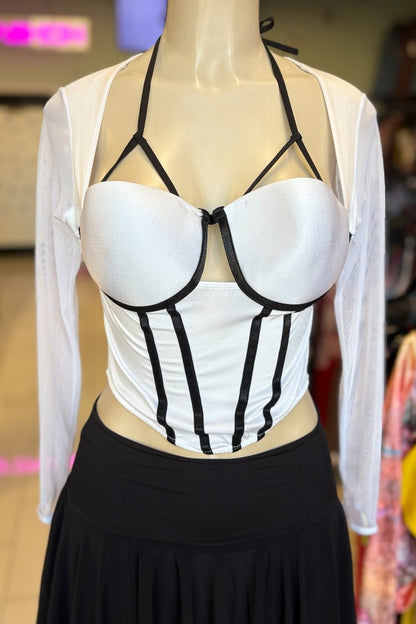 Mannequin wearing a white top with black straps and a black skirt in an indoor setting.