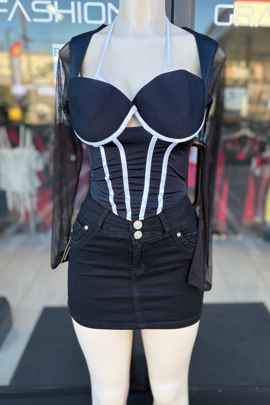 Mannequin wearing a black corset topwith white accents in front of a store window.