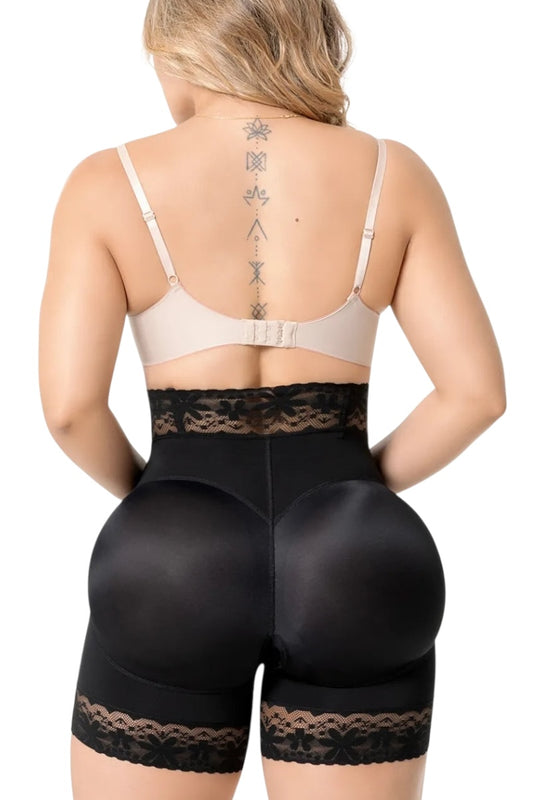 Person wearing a beige bra and black shapewear shorts on a white background