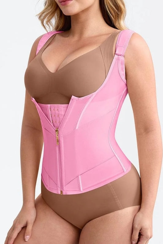 Woman wearing a pink waist trainer over a beige bra and panties on a white background