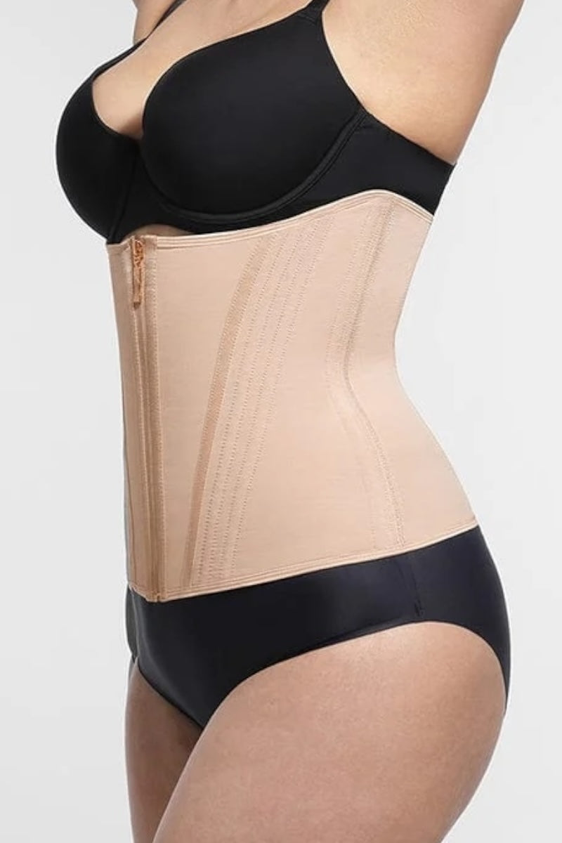 Beige waist trainer worn over black bra and panties on a white background