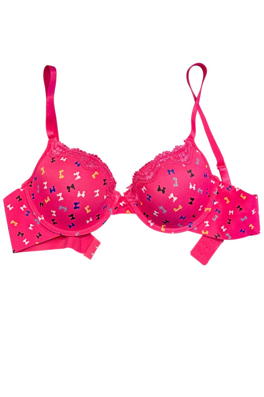 Pink bra with colorful bow pattern on a white background