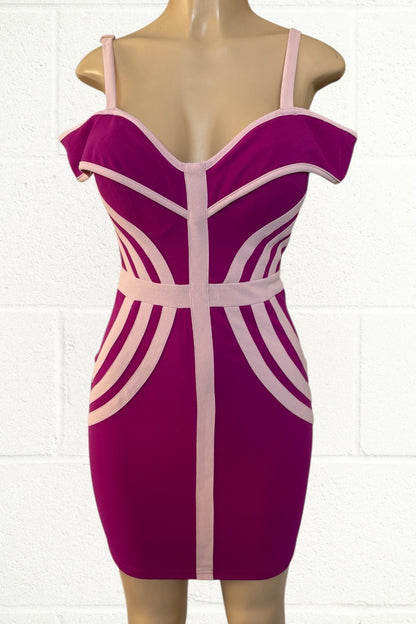 pink dress with beige accents on a mannequin against a white tiled wall.