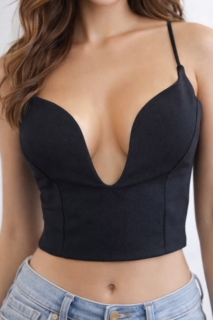 Black crop top worn by a person with a plain background
