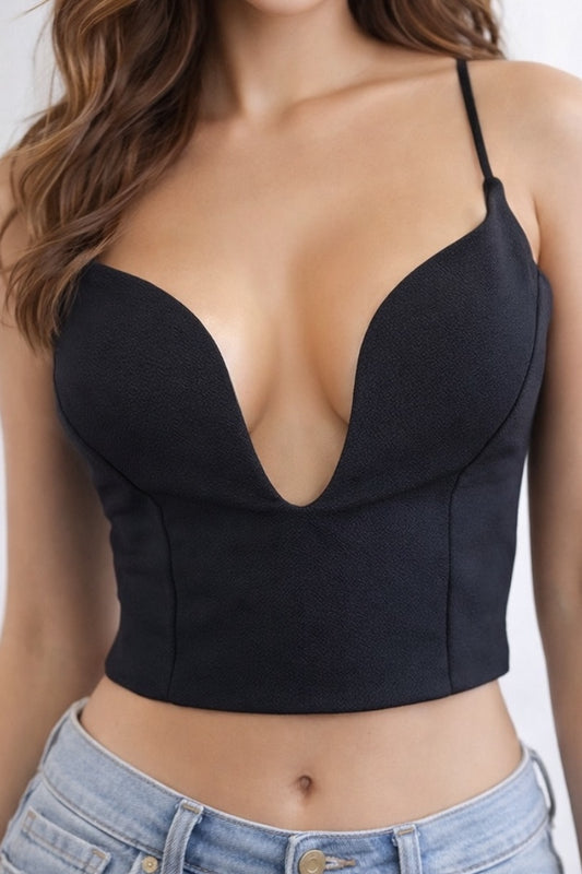 Black crop top worn by a person with a plain background