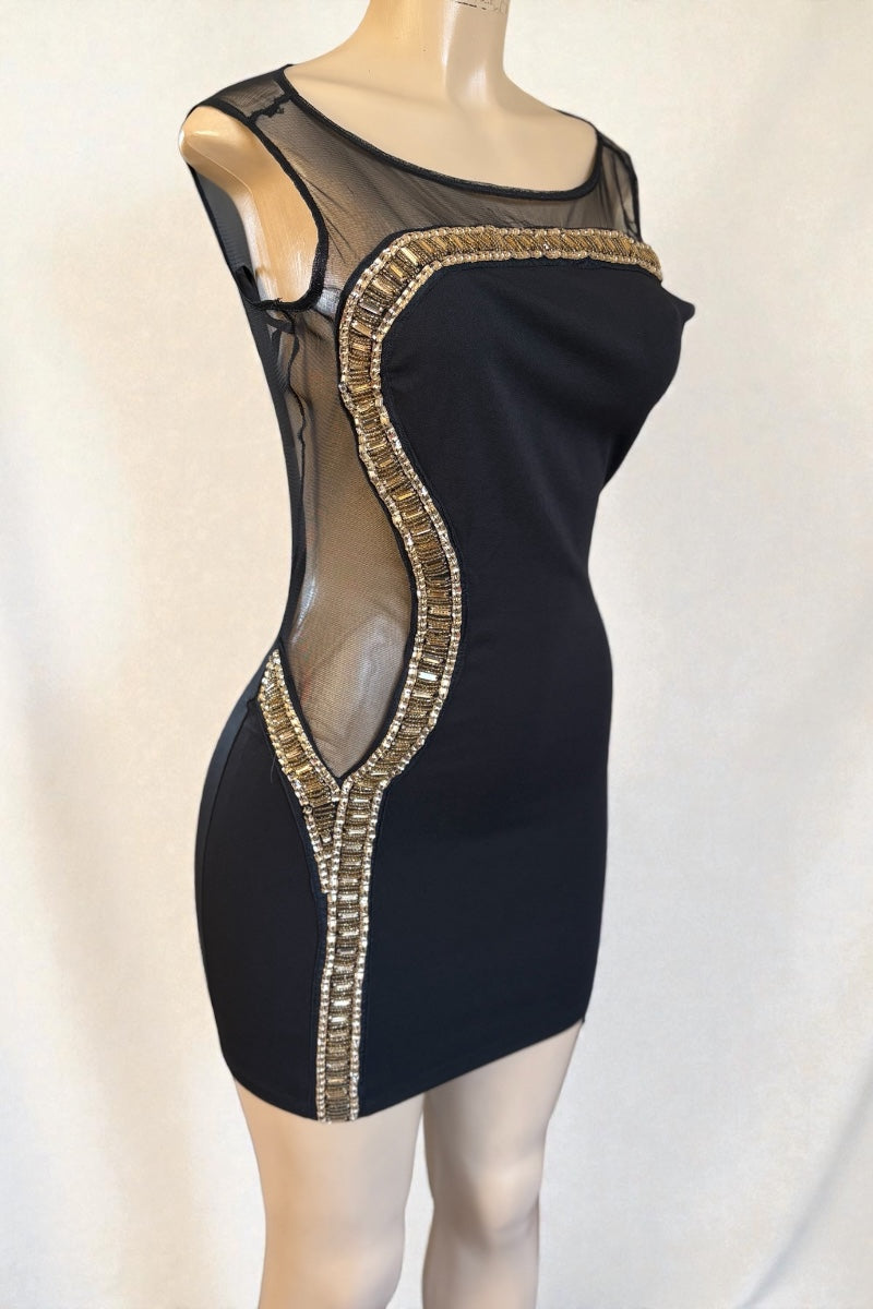 Black dress with sheer mesh and gold trim on a mannequin against a white background