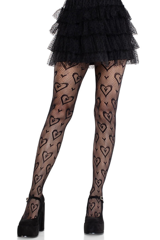 Black tights with a repeating heart pattern, worn by a model with a black ruffled mini skirt and black platform heels against a white background.