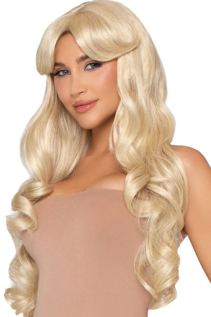 A woman wearing a long, wavy platinum blonde wig with bangs, styled in voluminous curls, shown against a plain white background.