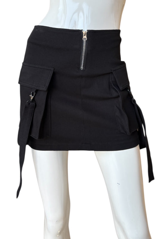 Black skirt with multiple pockets and zippers on a mannequin against a white background