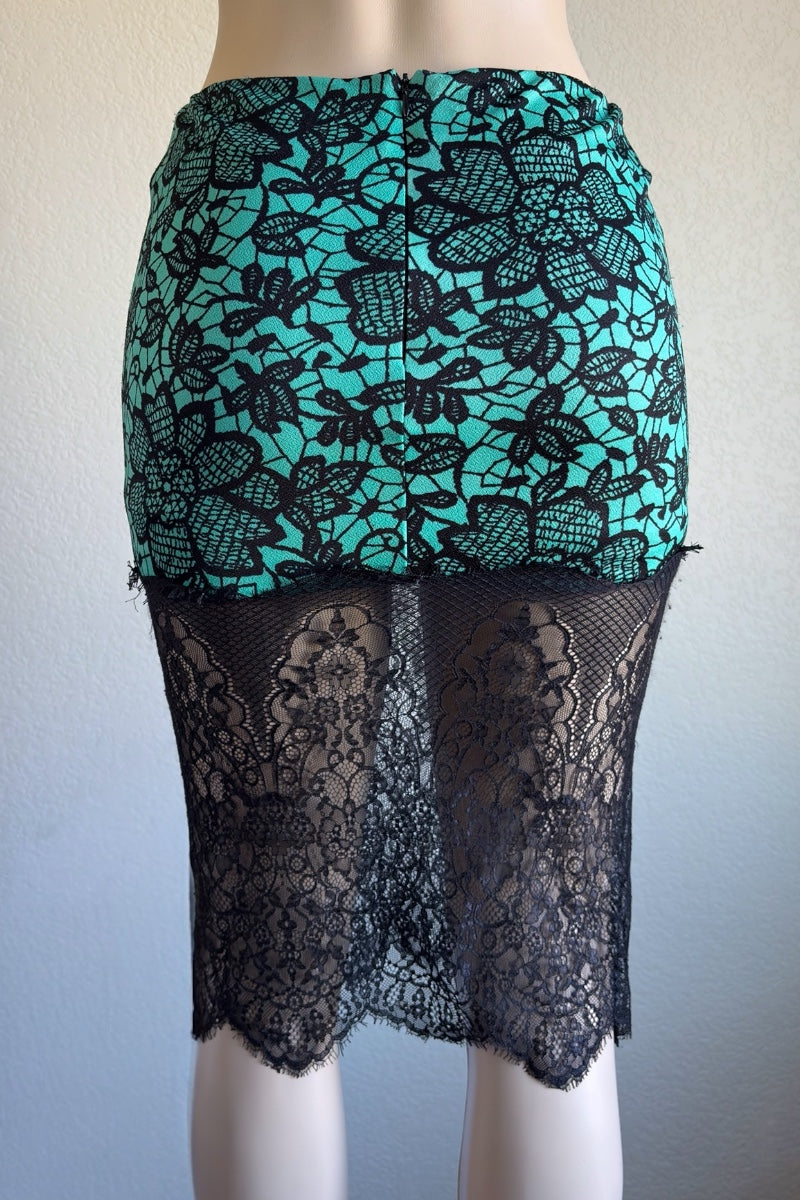 Teal and black lace skirt on a mannequin against a plain background