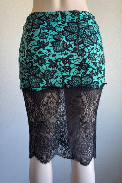 Teal and black lace skirt on a mannequin against a plain background
