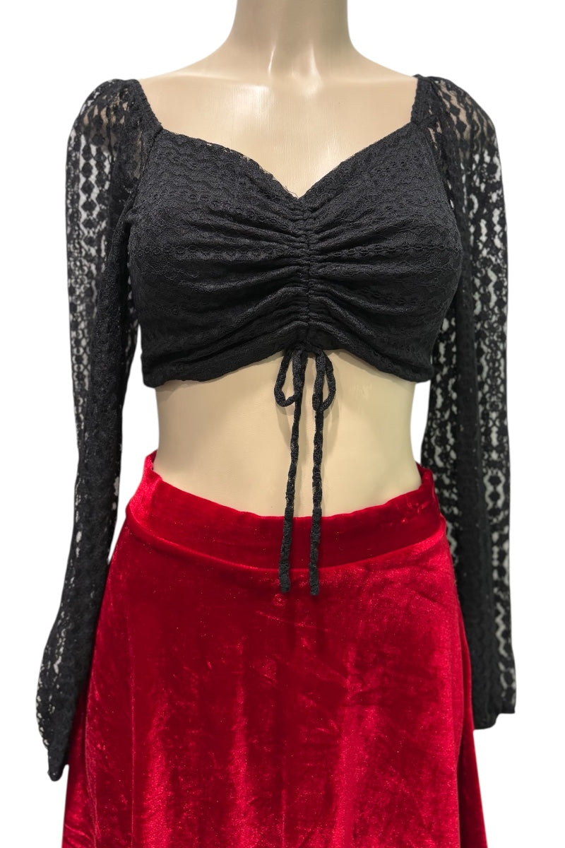 Mannequin wearing a black long-sleeve top with lace details and a red skirt on a white background