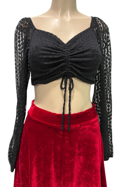 Mannequin wearing a black long-sleeve top with lace details and a red skirt on a white background