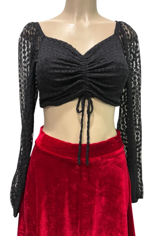 Mannequin wearing a black long-sleeve top with lace details and a red skirt on a white background