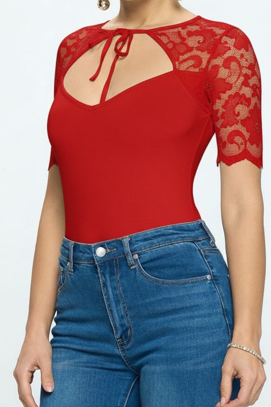 Red lace top with cut-out design and blue jeans on a white background