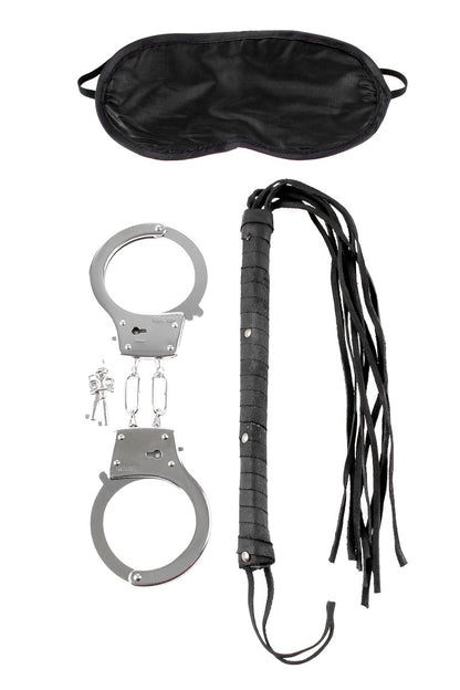 Set of handcuffs, black leather whip, and black satin eye mask on a white background