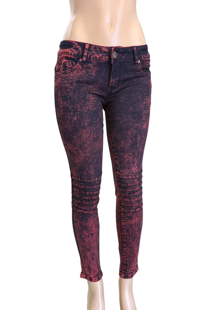 Red and black patterned jeans on a mannequin against a white background