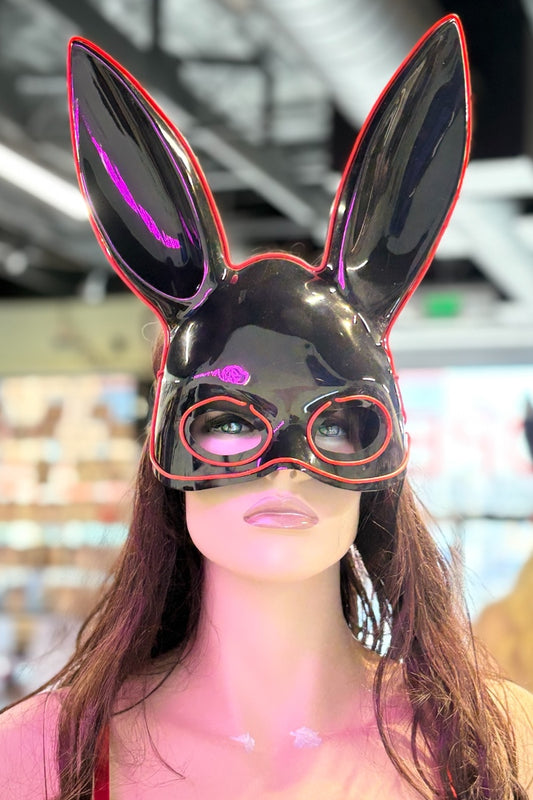 Person wearing a black bunny mask with red accents in an indoor setting