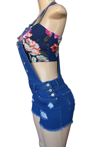 Blue denim overalls with floral top on a mannequin against a white background