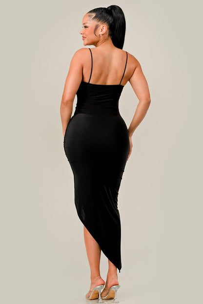 Woman wearing a black dress with thin straps on a plain background