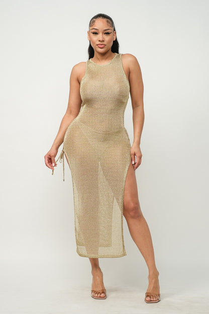 Woman wearing a light gold sleeveless dress with a slit on a white background