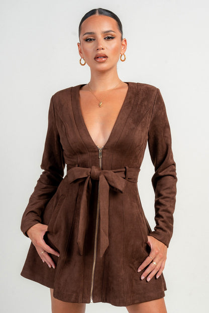 Woman wearing a brown chocolate suede dress with a belt on a white background