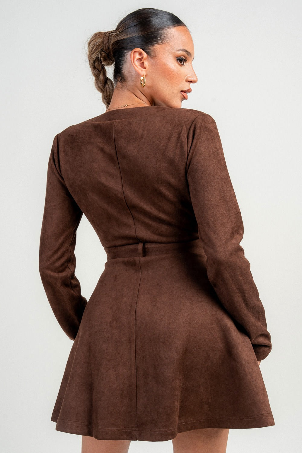 Woman wearing a brown chocolate dress with a plain background