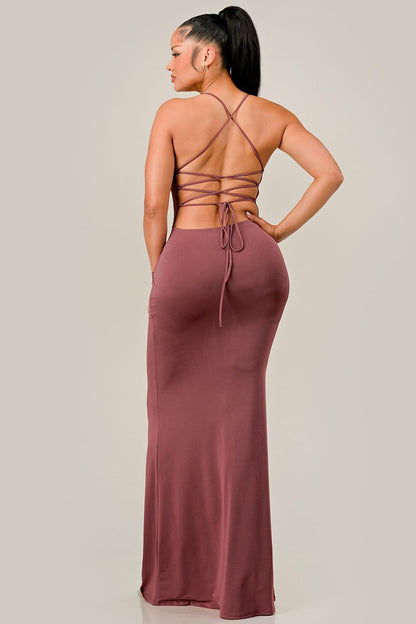 Woman wearing a red brown dress with a strappy back design on a plain background