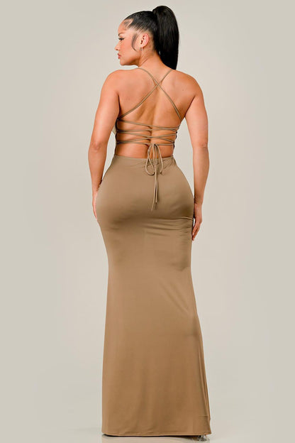 Woman wearing a beige cocoa dress with a backless design on a plain background