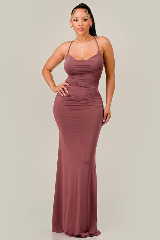 Woman wearing a red brown evening gown against a plain background
