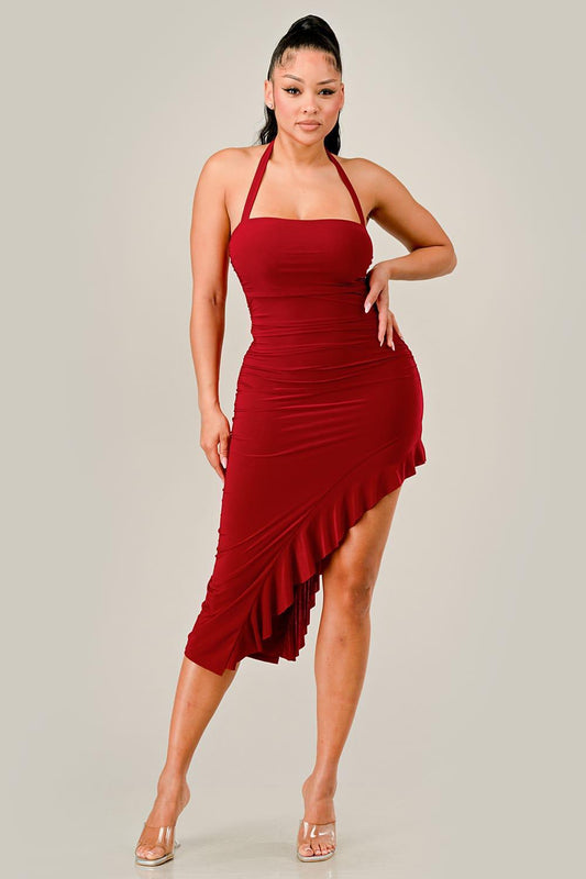 Woman wearing a red halter dress with ruffled skirt on a plain background