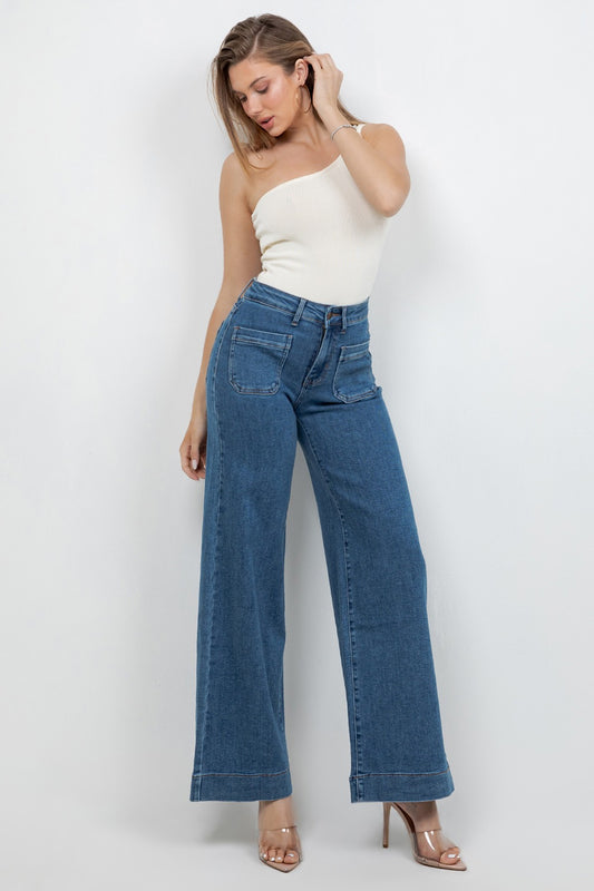 Woman wearing a white strapless top and blue jeans against a white background