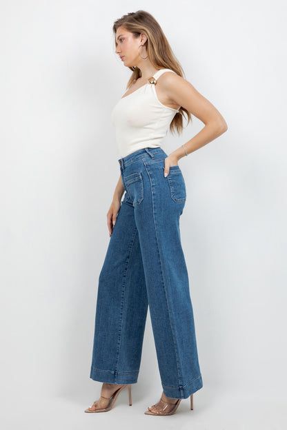 Woman wearing blue wide-leg jeans and a white top on a white background