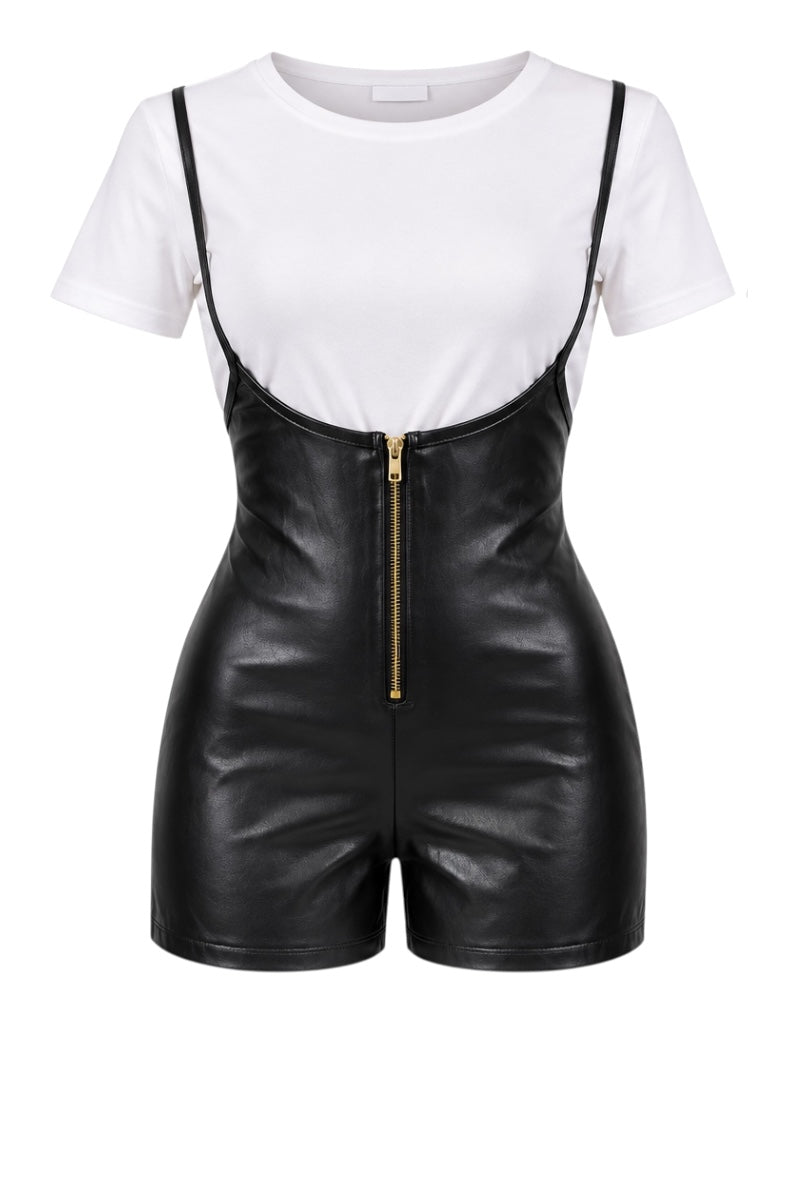 A black faux leather romper with thin shoulder straps, a gold front zipper, and a white short-sleeve crewneck bodysuit underneath, shown on a plain white background.